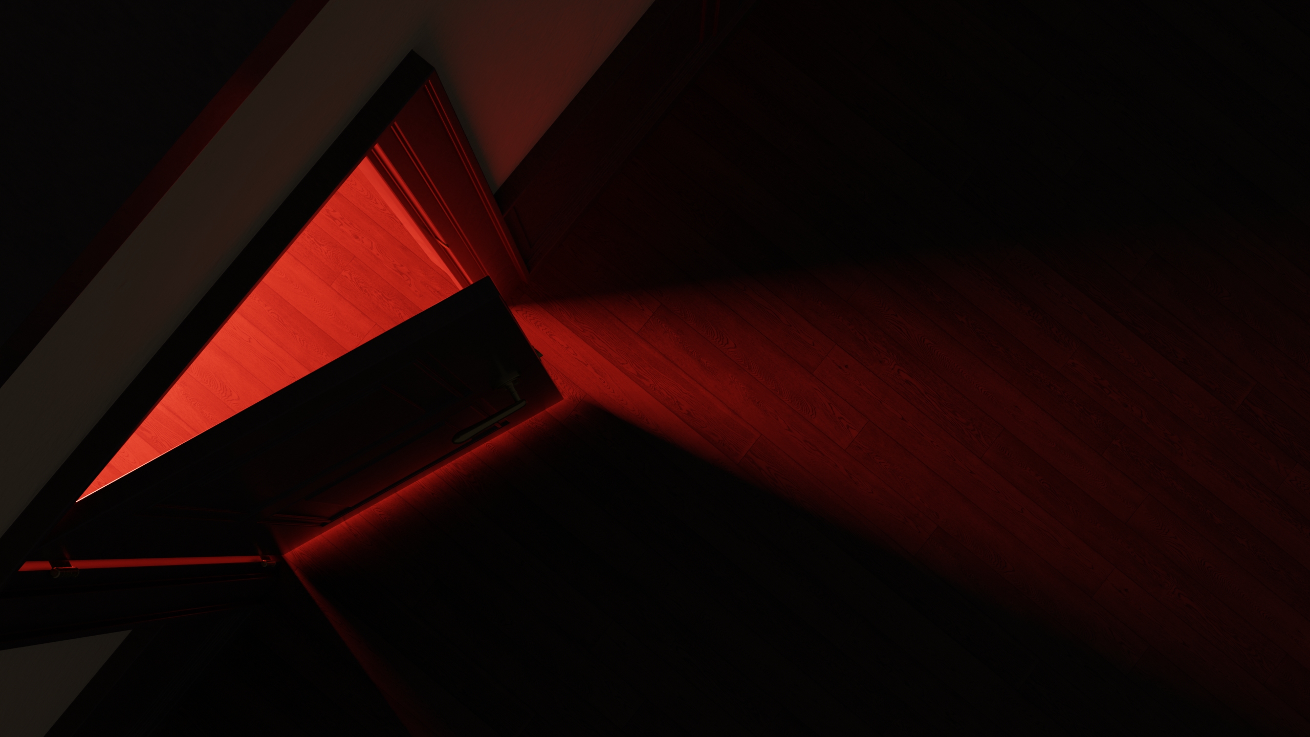 Overhead view of an open door casting red light across wooden floorboards